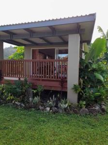 a porch of a house with a deck at Dominic's Beach Bungalow in Muri