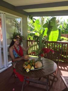 MuriにあるDominic's Beach Bungalowの食べ物の皿を持ってテーブルに座っている女性