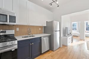 a kitchen with white cabinets and a stainless steel refrigerator at Jersey City Monthly Boutique 20 Min to NYC in Jersey City