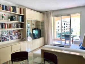 ein Wohnzimmer mit einem Sofa, einem Tisch und einem Fenster in der Unterkunft Monaco Port de Fontvieille refined apartment overlooking gardens, with open air swimming-pool in Monte Carlo