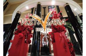 名取市HOTEL VISTA SARA - Adult Only的一家挂着圣诞老人酒店标志和红色花朵的商店