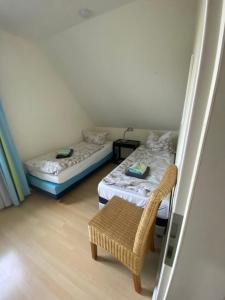 um pequeno quarto com 2 camas e uma cadeira em Am Jungfernberg 2 em Rankwitz