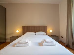 a bedroom with a white bed with towels on it at Big apartment close to Bocconi / Humanitas / IEO in Milan