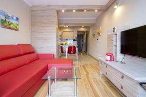 a living room with a red couch and a flat screen tv at Tęczowe Wzgórze in Wisła +122 photos