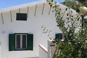 una casa blanca con persianas verdes y un árbol en La Dimora di Don Salvatore, en Caltanissetta