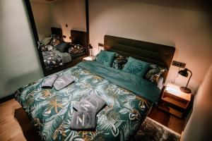 a bedroom with a large green bed with a mirror at Apartman Saturn in Osijek