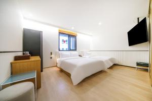 a bedroom with two beds and a flat screen tv at Busan H-AVENUE Hotel Seomyeon Station in Busan
