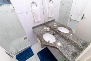 ein Bad mit einem Waschbecken und einer Dusche in der Unterkunft Girl From Ipanema Apartment in Rio de Janeiro