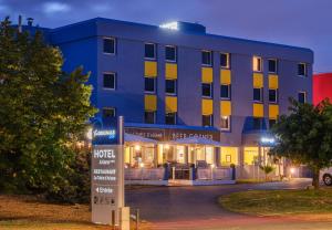 a hotel building with a sign in front of it at The Originals City, Hotel Ariane, Toulouse in Toulouse