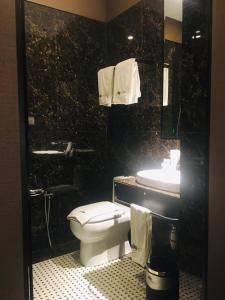 a black bathroom with a toilet and a sink at 1969 Business Suites in Ipoh