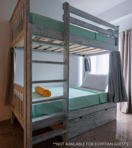 Etagenbett in einem Zimmer mit einer Leiter in der Unterkunft Tranquilo Boutique Hostel - Dahab in Dahab