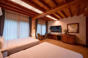 a bedroom with two beds and a flat screen tv at Jeonju Wangyijimil Hanok Hotel in Jeonju