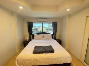 Cette chambre comprend un grand lit et une fenêtre. dans l'établissement The Sports Lounge, à Pattaya