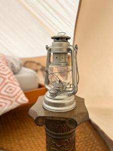 a glass lantern sitting on a wooden table at The Queens Head Glamping in Foulsham