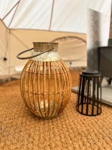 a gold vase sitting on the floor next to two stools at The Queens Head Glamping in Foulsham