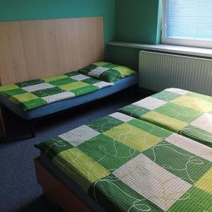 duas camas num quarto com verde e amarelo em Manhattan Penzion em Písek
