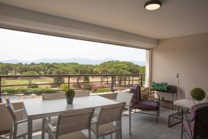 聖西普里安的住宿－Résidence Pierre & Vacances Premium Horizon Golf，客房设有桌椅和大窗户。