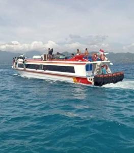 Un bateau avec des gens dans l'eau dans l'établissement Gili Ferries ticket, à Padangbai