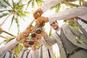 a group of men holding up bottles of beer at 7 Room TampaGolfVillas by AmericanVacationliving in Wesley Chapel +94 photos