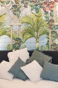 a bed with pillows and a mural of a palm tree at Appartamento a Capri a pochi passi dalla Piazzetta in Capri