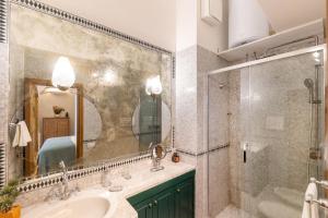 y baño con lavabo, ducha y espejo. en Appartamento a Capri a pochi passi dalla Piazzetta, en Capri