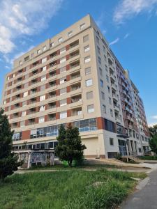 ein großes Apartmenthaus mit einem Baum davor in der Unterkunft Oaza 45 in Belgrad
