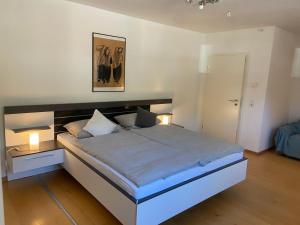 a bedroom with a large bed with two lamps on it at BnB-Home Apartment in Buxheim