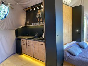 uma cozinha com um lavatório e uma cama num quarto em Poziom 713 em Trzebunia