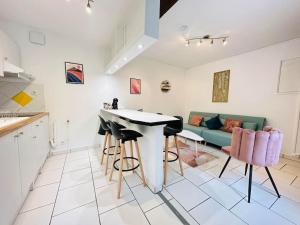 a kitchen and living room with a table and stools at Appartement Confidentiel in Laon