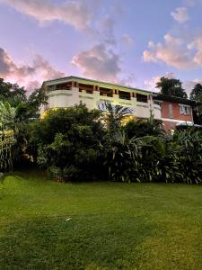 um edifício com um relvado verde em frente em Babinda Quarters em Babinda