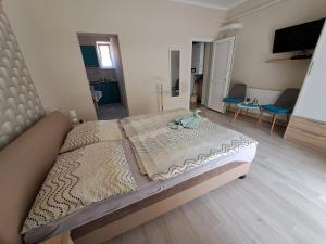 ハイドゥソボスローにあるBerta Panzióの大きなベッド1台(椅子2脚付)が備わるベッドルームです。