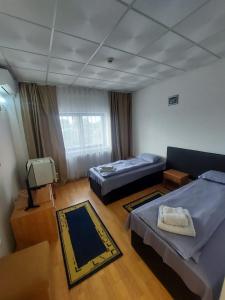 a room with two beds and a tv in it at Magnific Hotel in Borş