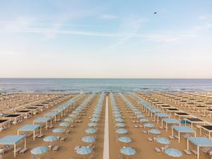a beach with chairs and umbrellas and the ocean at Re Versiliana Hotel in Marina di Pietrasanta