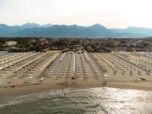 a beach with a lot of umbrellas and cars at Re Versiliana Hotel in Marina di Pietrasanta