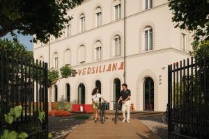 a man and a woman riding bikes in front of a building at Re Versiliana Hotel in Marina di Pietrasanta