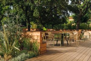a patio with chairs and tables in a garden at Re Versiliana Hotel in Marina di Pietrasanta