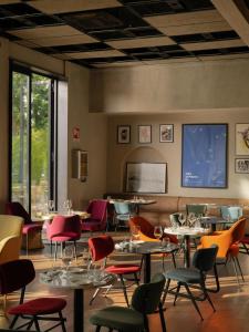 a restaurant with tables and chairs and a projection screen at Re Versiliana Hotel in Marina di Pietrasanta