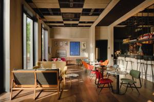 a restaurant with tables and chairs and a bar at Re Versiliana Hotel in Marina di Pietrasanta