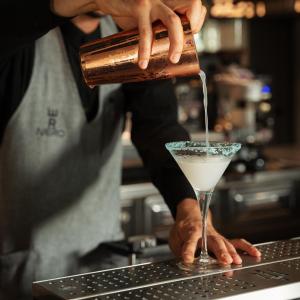 a bartender preparing a drink in a martini glass at Re Versiliana Hotel in Marina di Pietrasanta