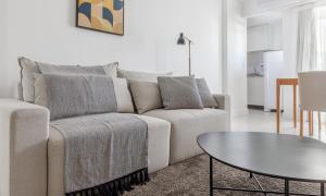 uma sala de estar com um sofá e uma mesa em Tabas Lindo apê 2 suítes Jd. Botânico JB0001 no Rio de Janeiro