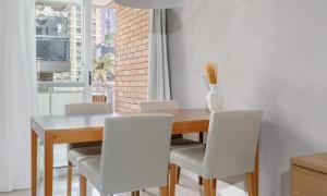 uma mesa de jantar com cadeiras e um vaso sobre ela em Tabas Lindo apê 2 suítes Jd. Botânico JB0001 no Rio de Janeiro