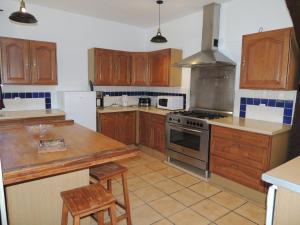 a kitchen with wooden cabinets and a stove top oven at LA VILLA QUI A DU CHIEN in Neuville-sur-Touques