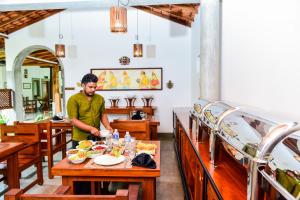 um homem a preparar comida numa mesa num restaurante em Samudra Villa em Ambalangoda