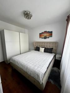 1 dormitorio con cama y lámpara de araña en Your cozy place en Târgu Mureș