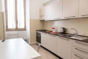 uma cozinha com armários brancos e um lavatório em Domus Viola in San Giovanni em Roma