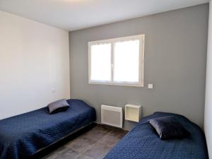 a bedroom with two beds and a window at Le Brasil - Maison 74 m - Calme avec terrasse Sud classée 3 étoiles in Le Boulou