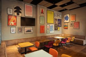 a restaurant with tables and chairs and pictures on the wall at Re Versiliana Hotel in Marina di Pietrasanta