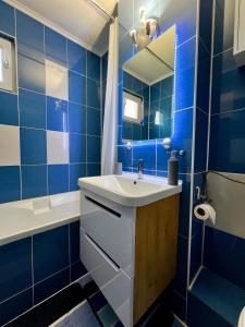 baño de azulejos azules con lavabo y bañera en Your cozy place en Târgu Mureș