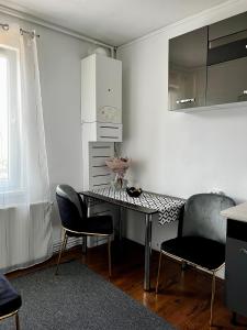 a kitchen with a table and two chairs in a room at Your cozy place in Târgu-Mureş