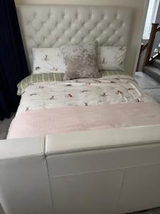 a white bed with a white headboard in a bedroom at Home from Home Cosy B&B in London